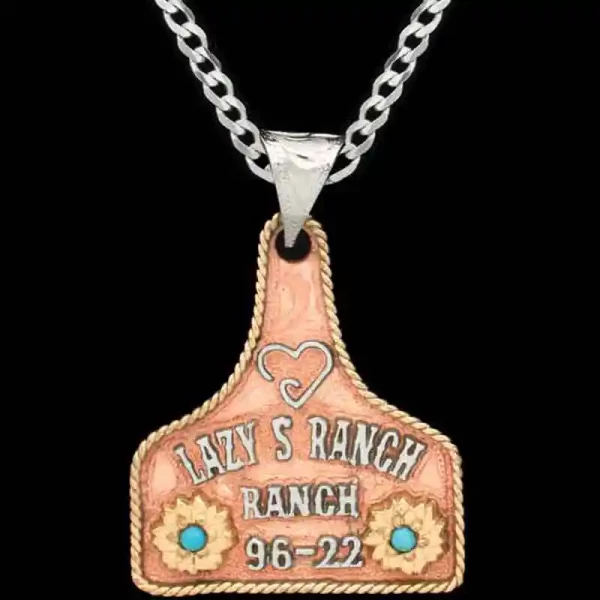 "Our Kali Custom Cow Tag Necklace crafted on a German Silver base with hand-engraved scrolls, it features a diamond simulated Turquoise stone, a hand-painted figure, and Jeweler's Bronze lettering, completed with our signature antique finish. Persona